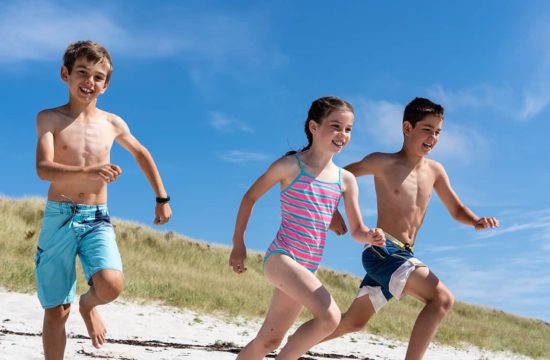 kids run on sandy beach